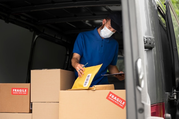 Medium shot delivery man with mask