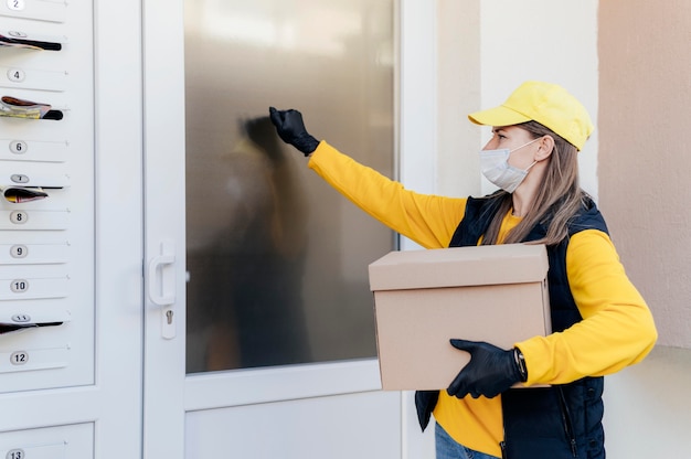 Free photo medium shot delivery woman holding box