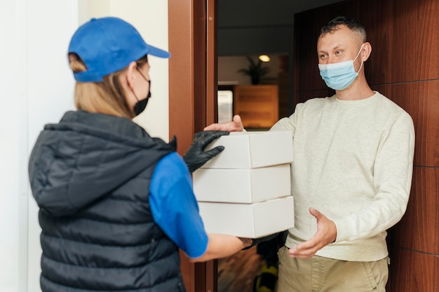 Medium shot delivery woman holding boxes