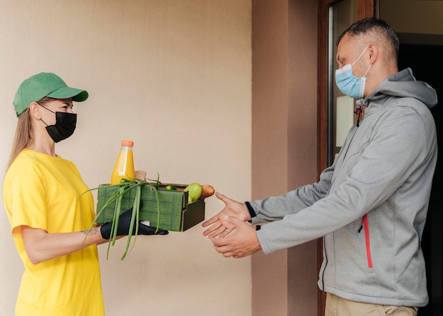 Free photo medium shot delivery woman holding crate