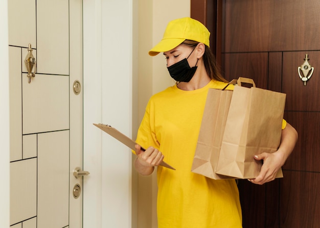 Medium shot delivery woman with mask