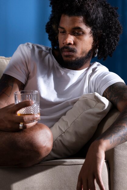 Medium shot depressed man with alcohol