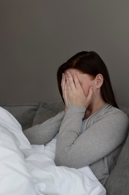 Foto gratuita donna depressa a tiro medio al chiuso