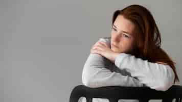 Free photo medium shot depressed woman sitting on chair