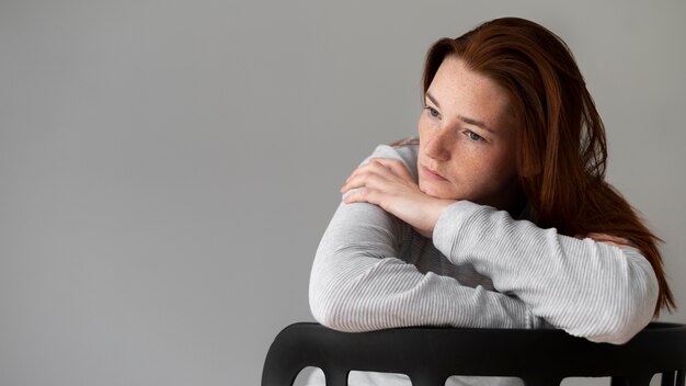 Medium shot depressed woman sitting on chair