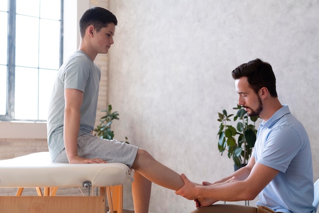 Medium shot doctor checking boy's leg