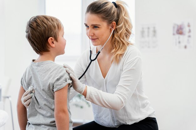 Medium shot doctor checking kid