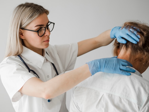 Foto gratuita medico del colpo medio che controlla paziente