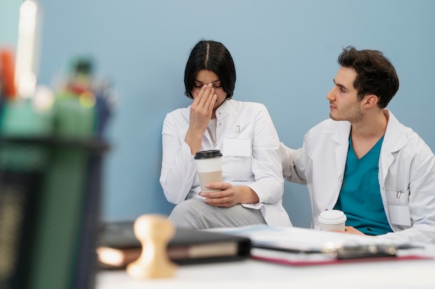 Free photo medium shot doctor comforting fellow