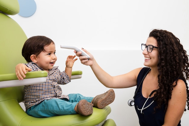 Medium shot doctor examining baby boy