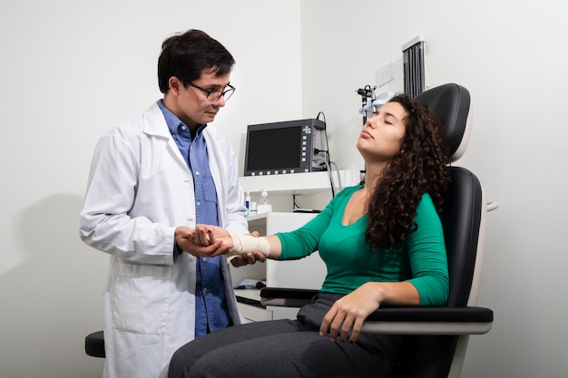 Medium shot doctor examining bandaged arm