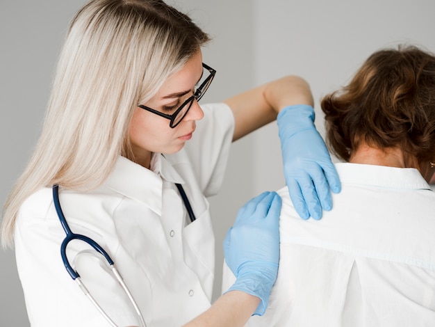 Medium shot doctor examining patient