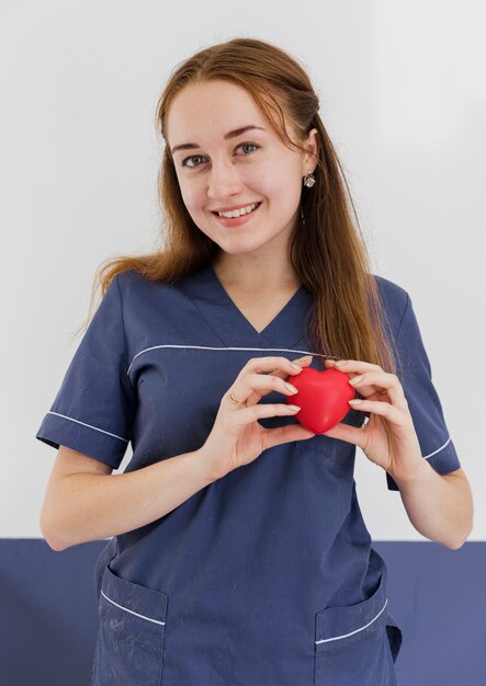 Medium shot doctor holding heart shaped toy