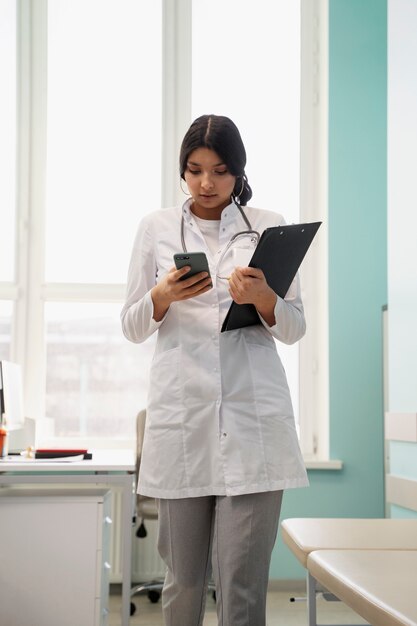 Medium shot doctor holding smartphone