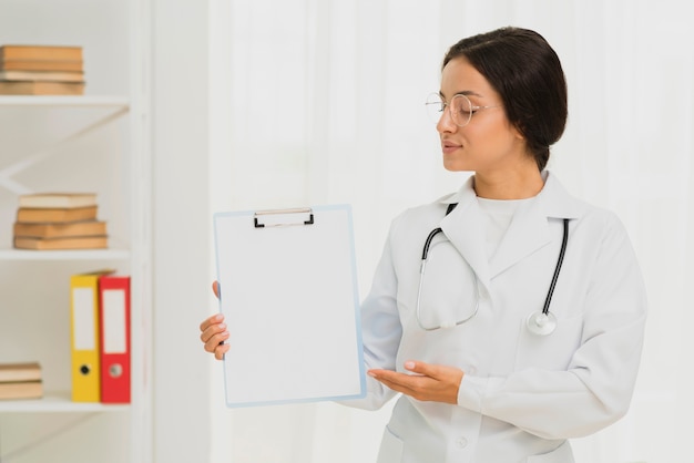 Medium shot doctor holding up a clipboard