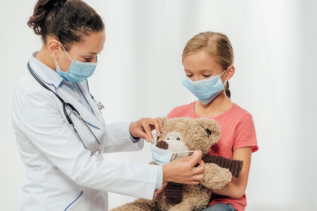 Foto gratuita medico di tiro medio e bambino che indossano maschere