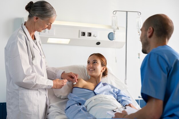 Medium shot doctor and nurse helping woman