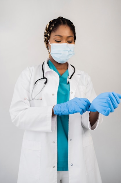 Free photo medium shot doctor putting on gloves