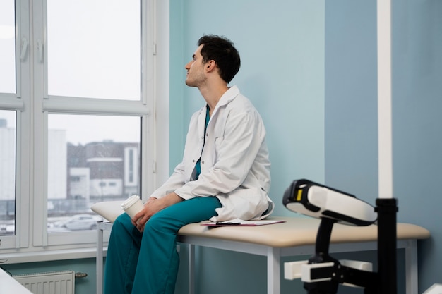 병원에 앉아 있는 중간 샷 의사