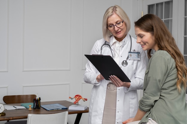 Medium shot doctor talking to smiley patient