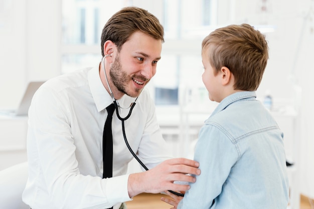 Free photo medium shot  doctor using stethoscope