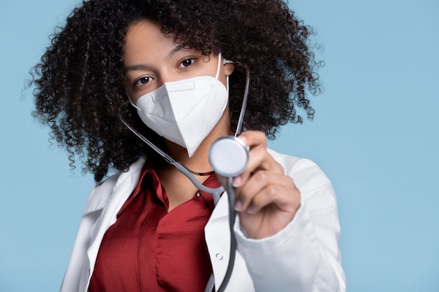 Medium shot doctor wearing mask and stethoscope