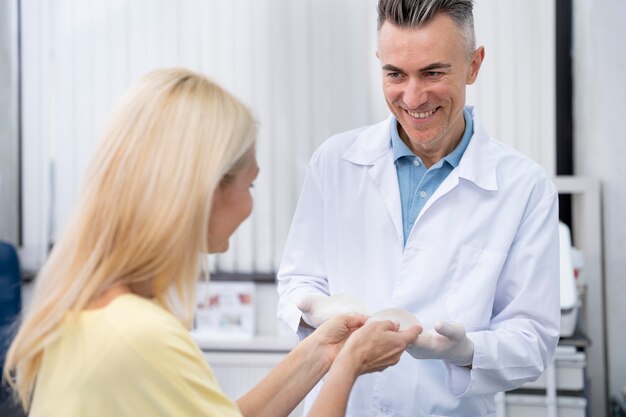 Medium shot doctor and woman with breast implants