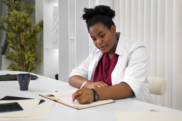 Medium shot doctor writing in notebook