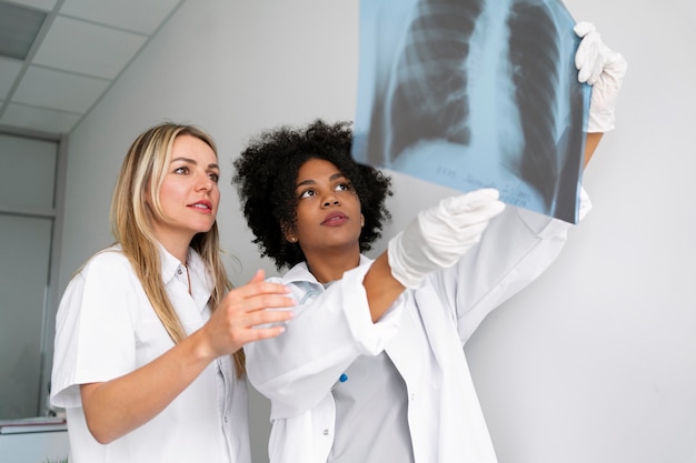 Foto gratuita medici del campo medio che esaminano la radiografia