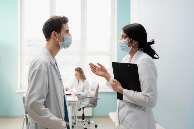 Medium shot doctors talking with masks