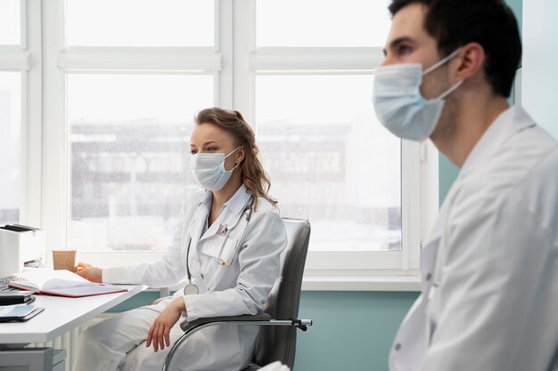 Medium shot doctors wearing face masks
