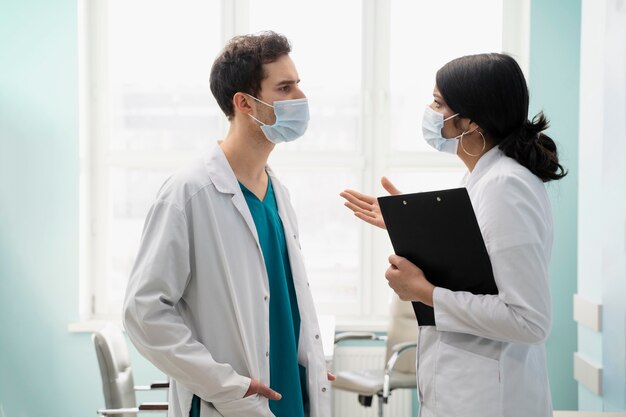 Medium shot doctors with masks talking