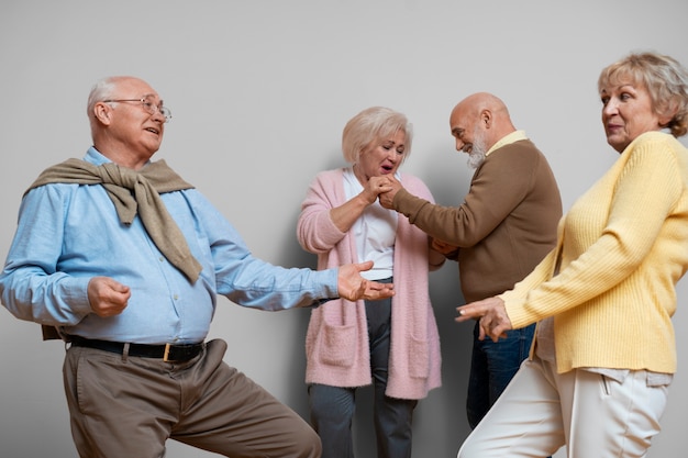 Free photo medium shot elder friends dancing together