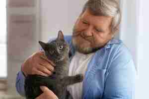 Free photo medium shot elderly man with cat