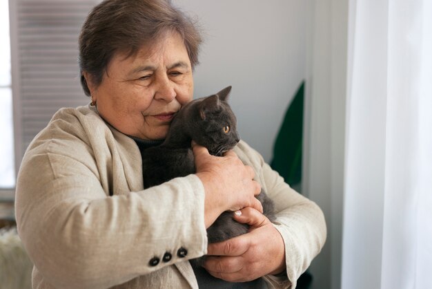 猫とミディアムショットの年配の女性