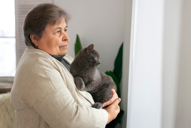 Medium shot elderly woman with cat