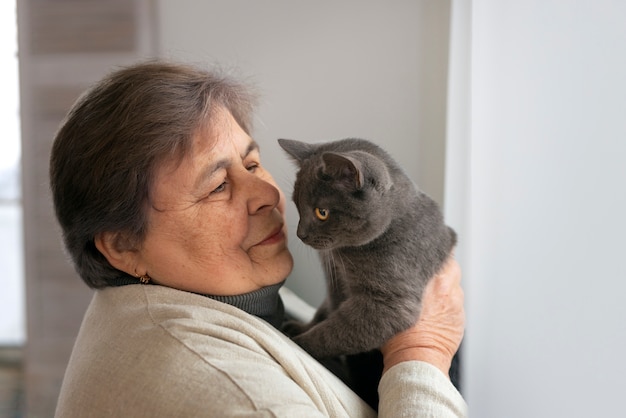 猫とミディアムショットの年配の女性