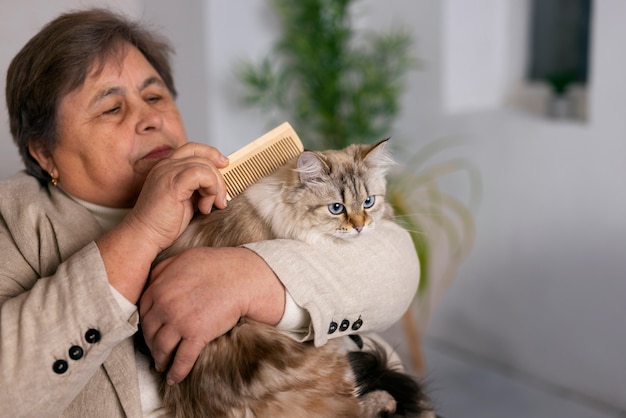 고양이와 중간 샷 노인 여성