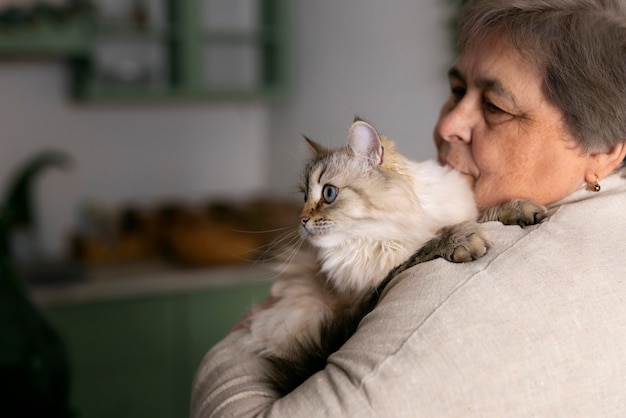 猫とミディアムショットの年配の女性