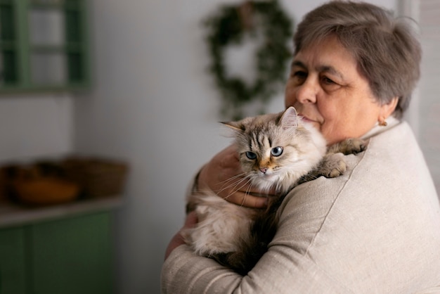 Medium shot elderly woman with cat