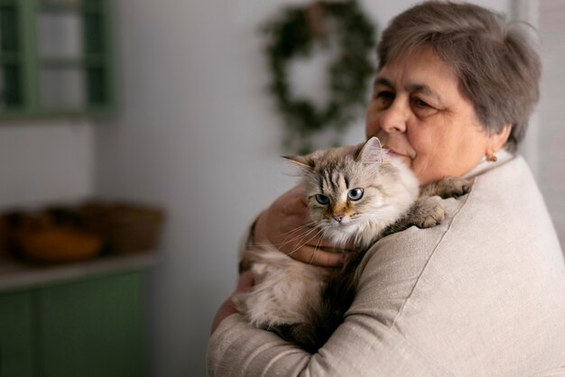 Пожилая женщина среднего роста с кошкой