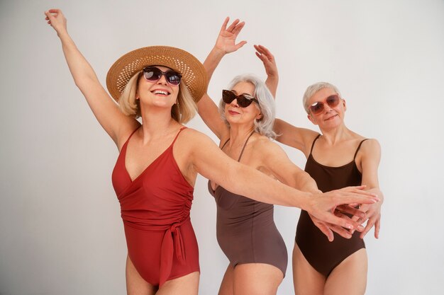 Medium shot eldery women in swimsuits posing