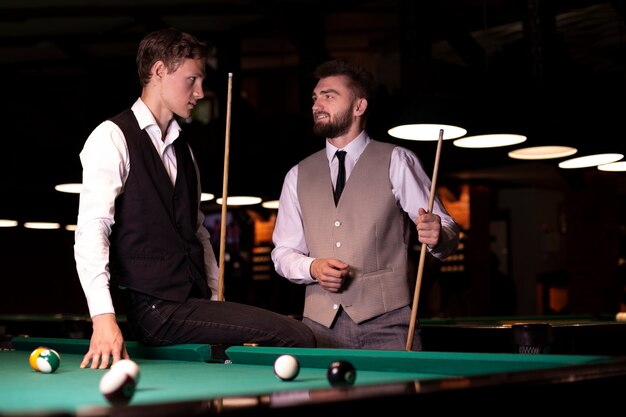 Medium shot elegant men with pool cues