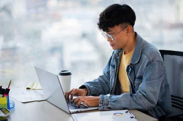 Medium shot employee working on laptop