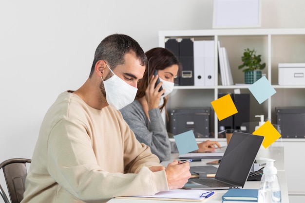 Medium shot employees with mask