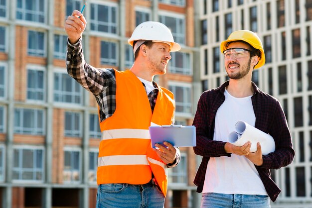 Medium shot of engineer and architect supervising construction