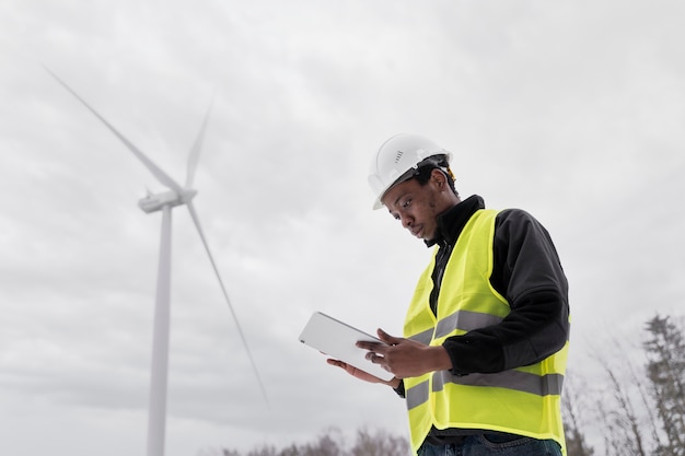 Free photo medium shot engineer holding tablet