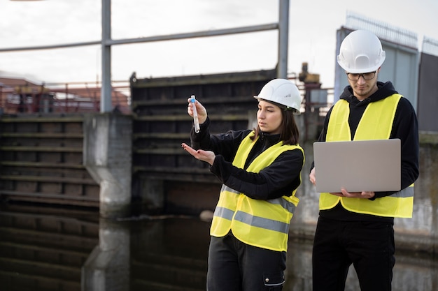 Free photo medium shot engineers with water sample