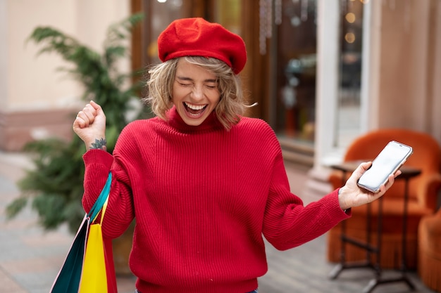 Medium shot excited woman holding smartphone