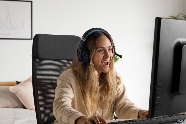 Medium shot excited woman playing on computer